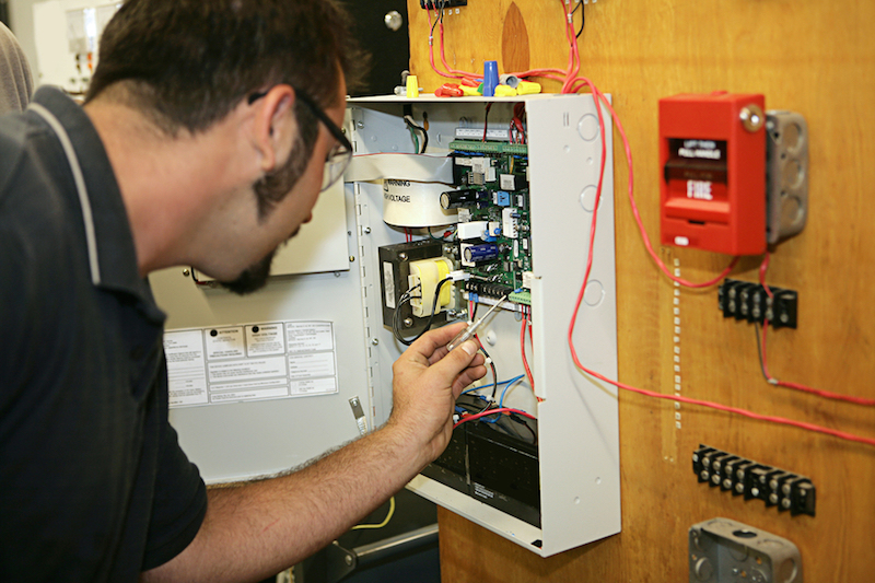 A man installing a fire alarm system